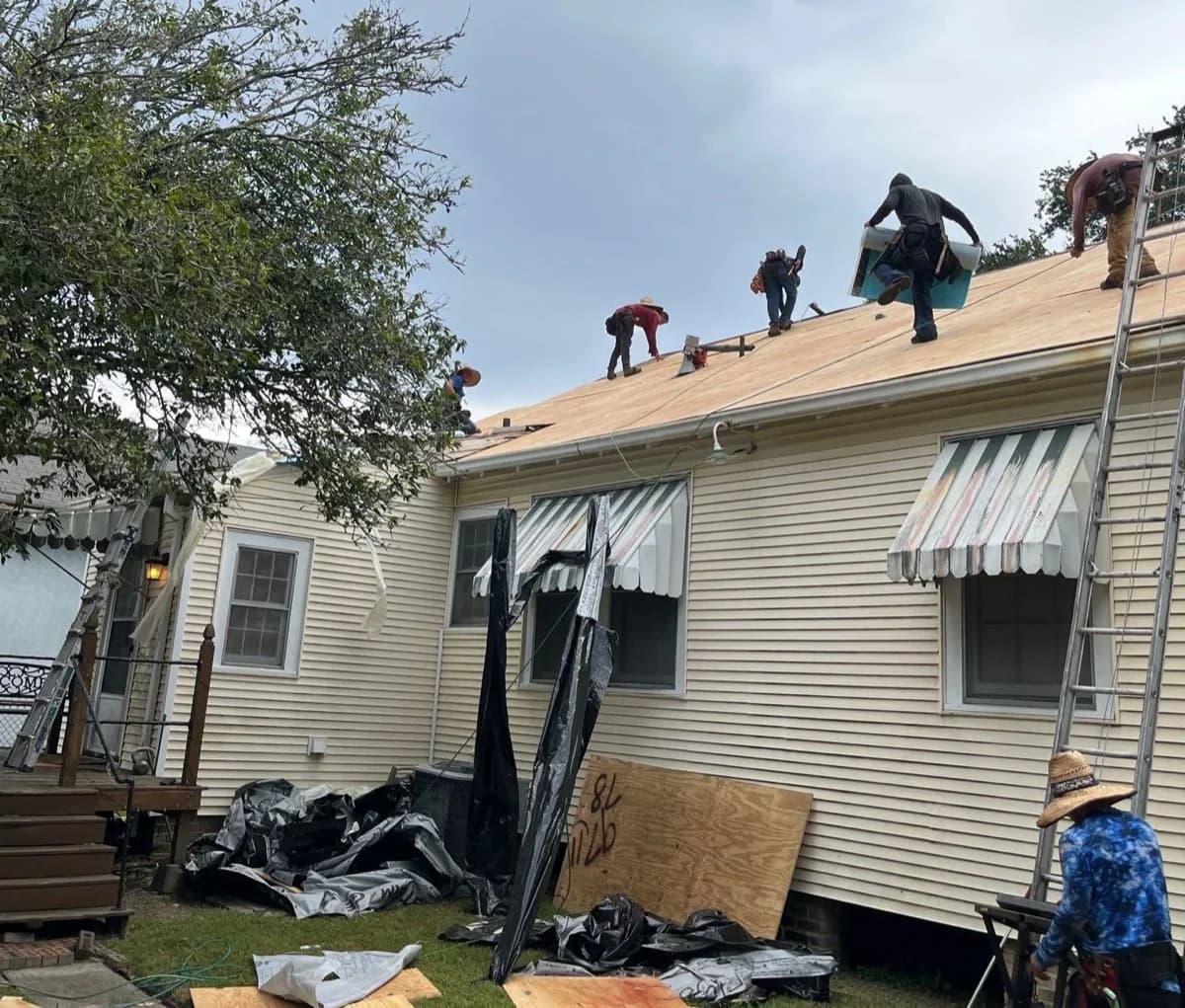 Professional roofing contractor reviewing plans with homeowner in front of Texas home