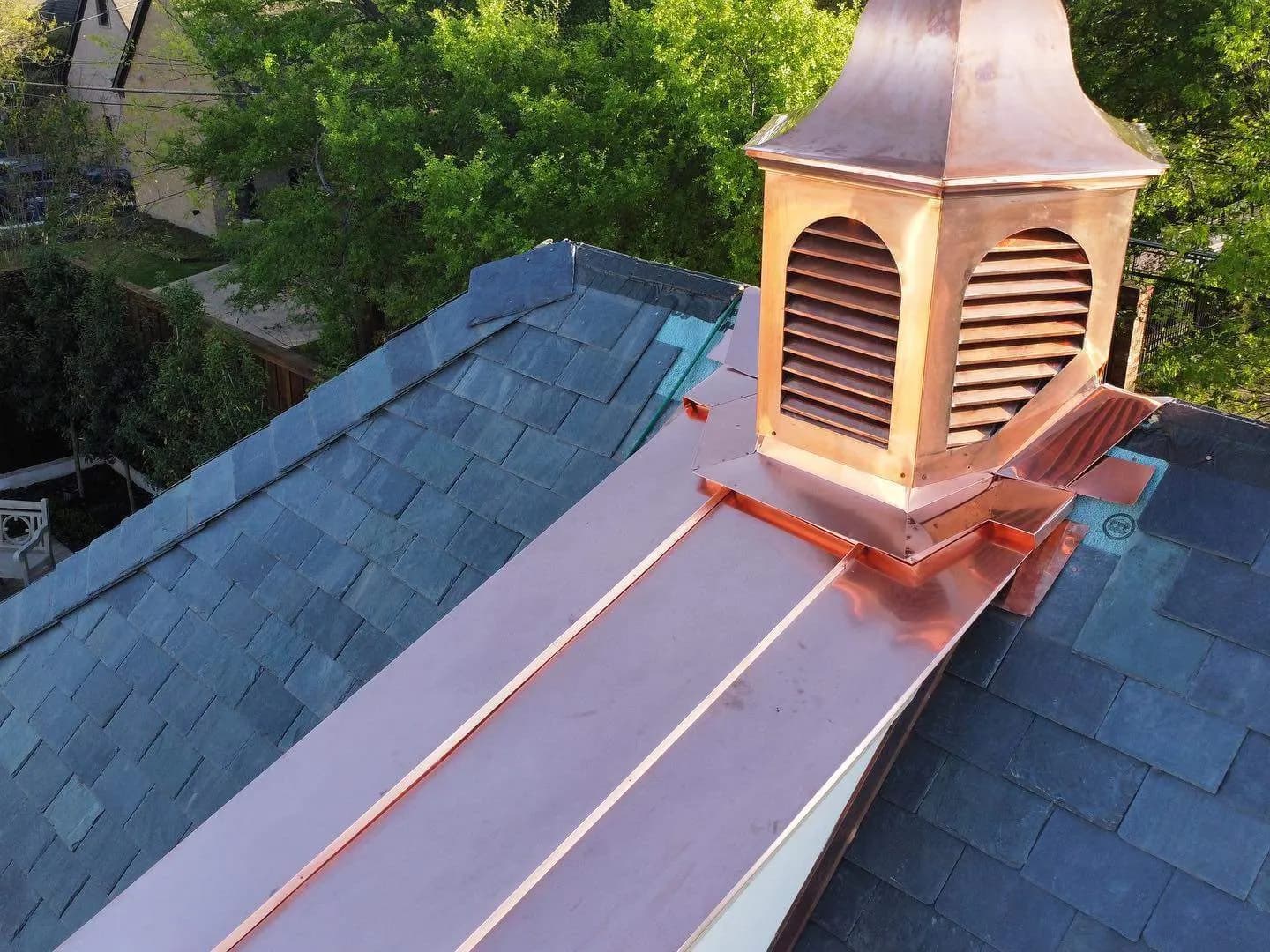 Copper cupola finial and slate ridge close-up