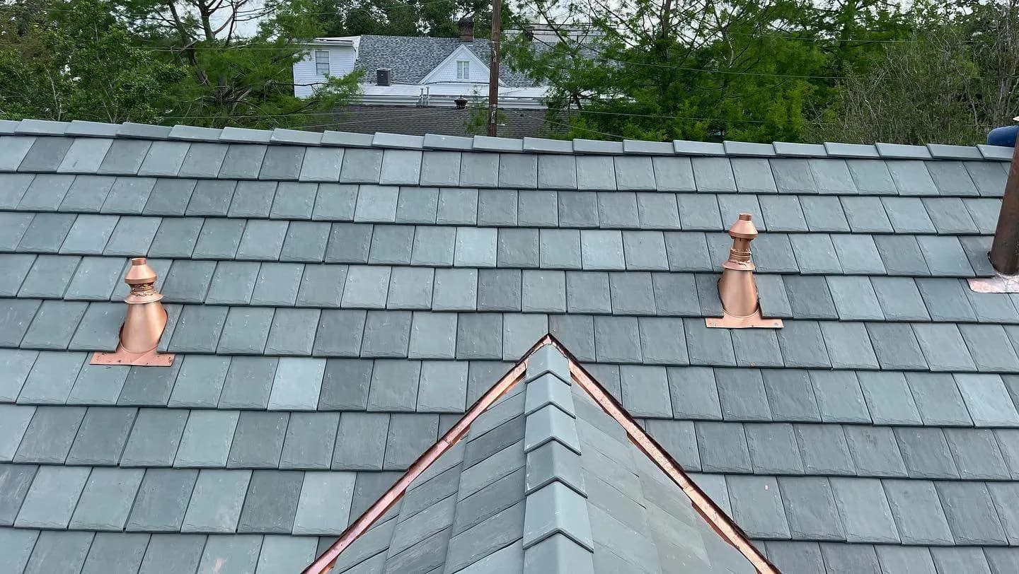 Copper vent caps integrated into a slate roof