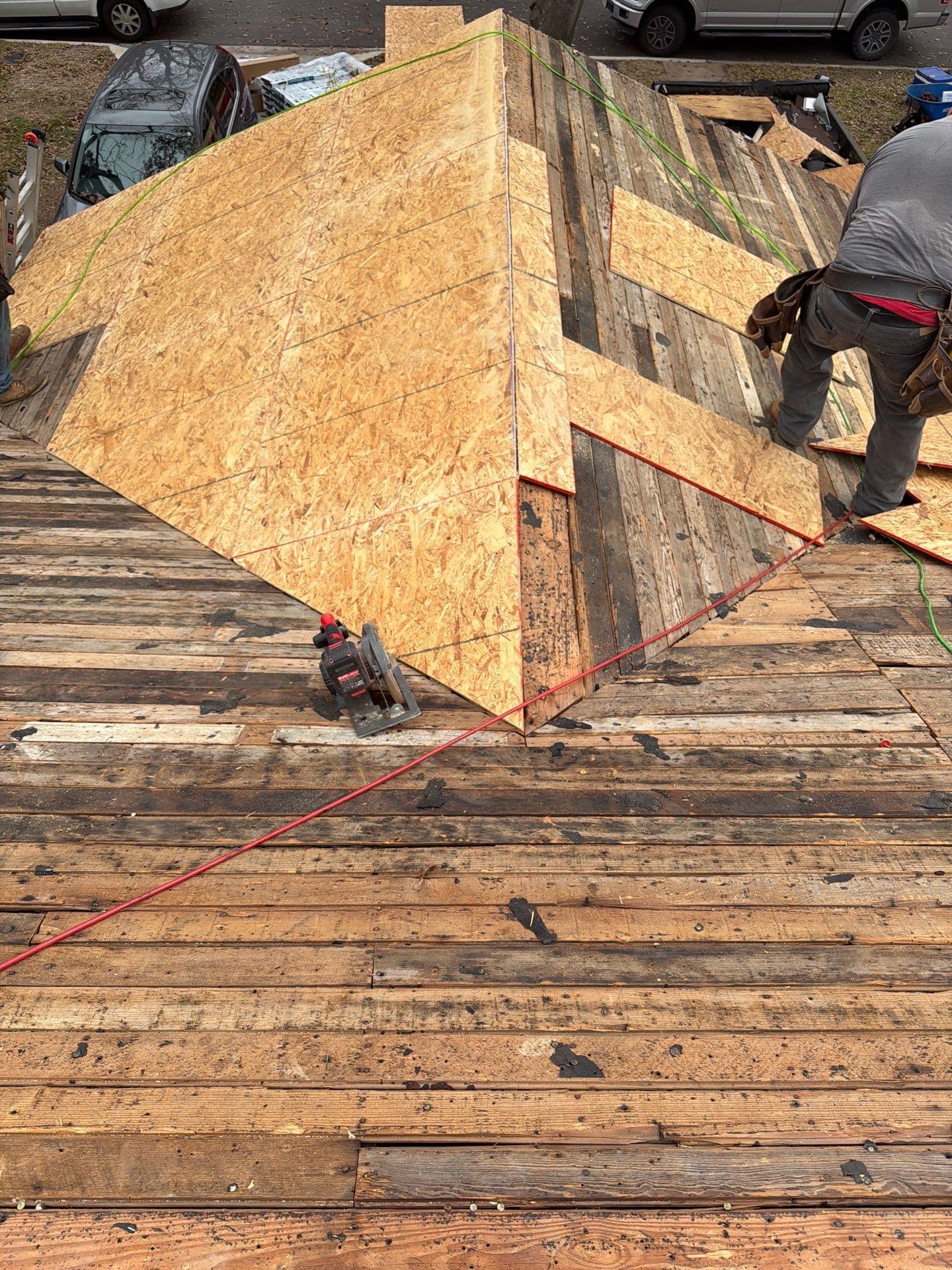 New OSB roof decking being installed over exposed board decking during an Austin roof replacement