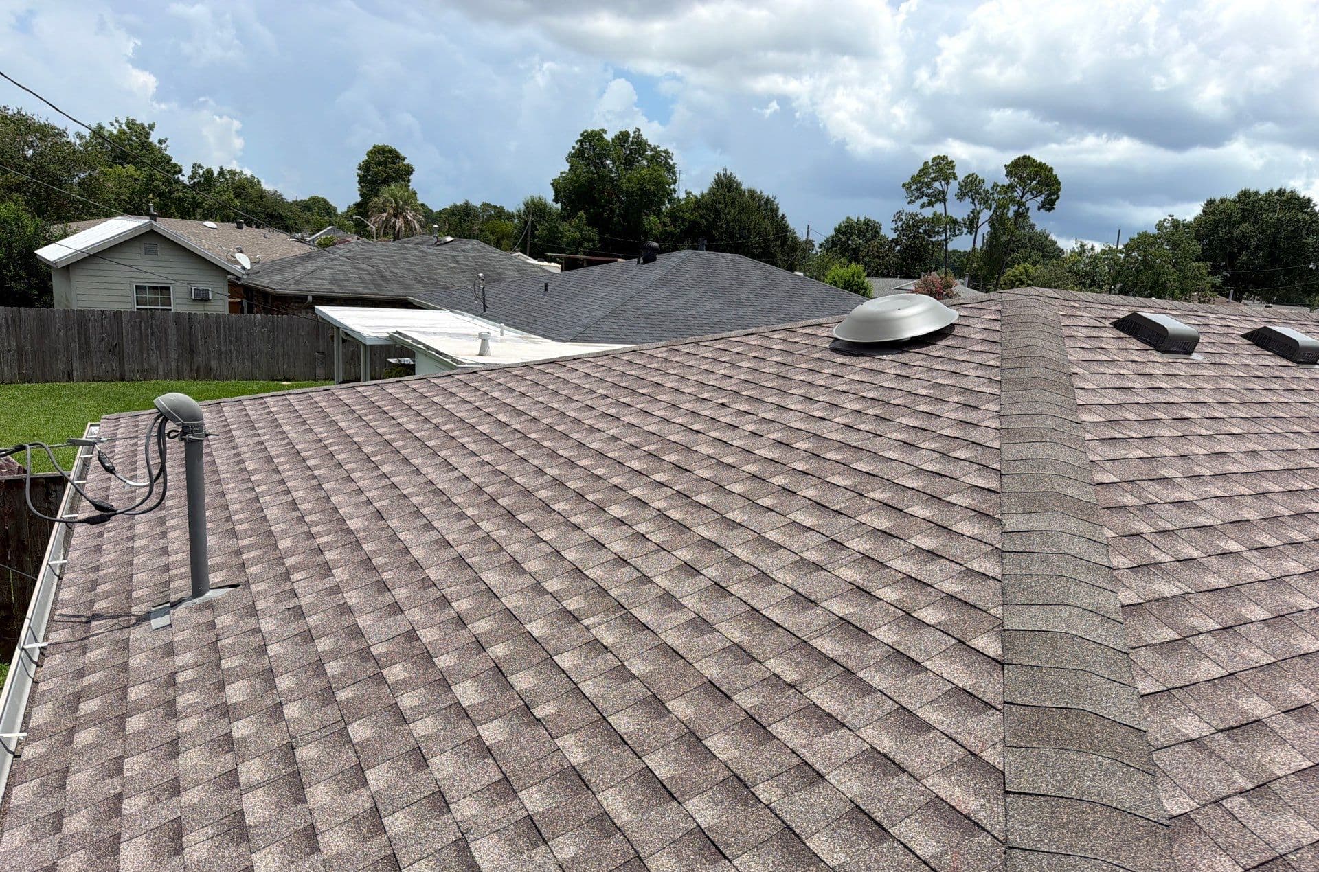 Architectural shingles and hip caps with round and rectangular roof vents on a Harahan replacement