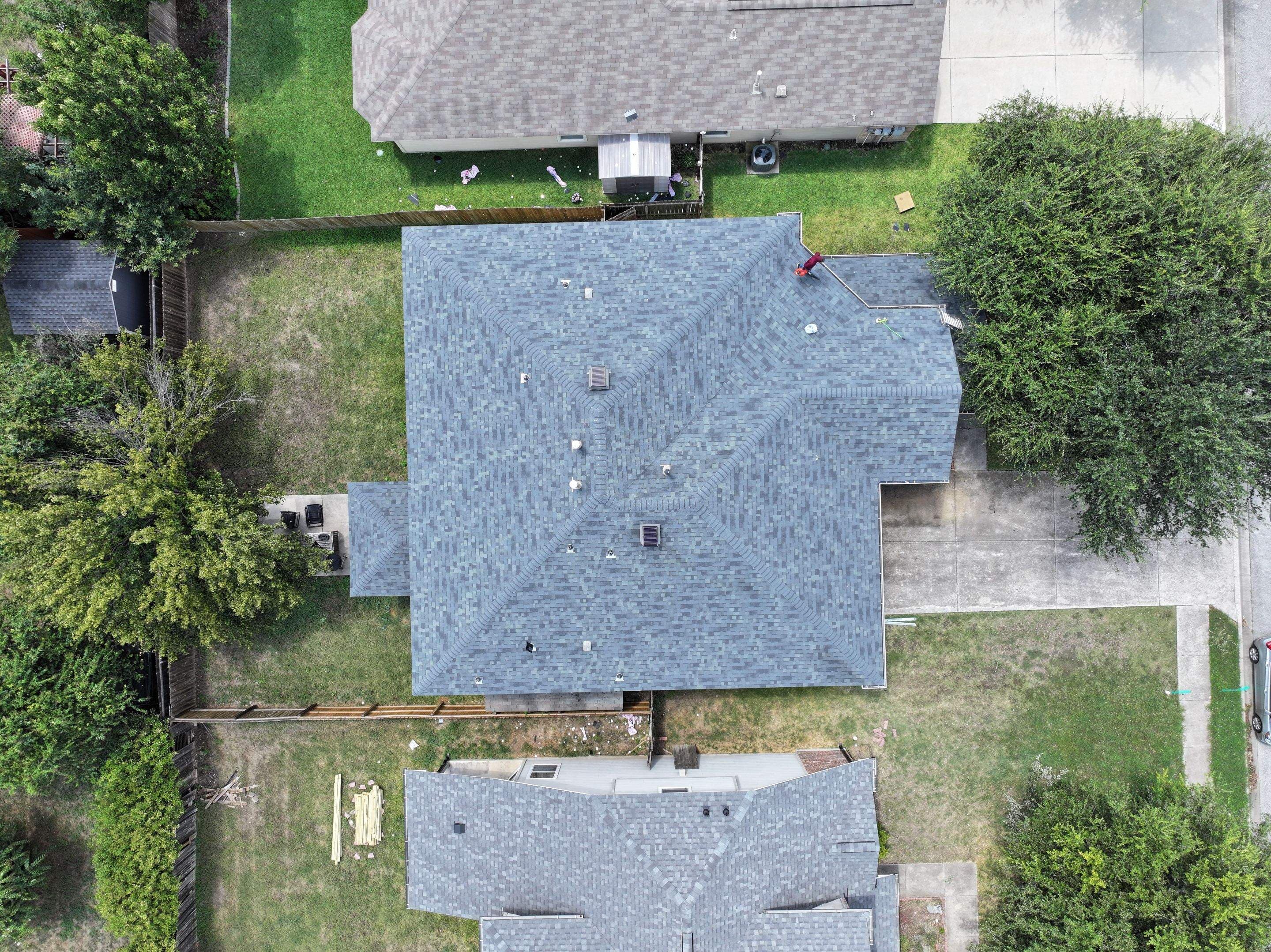 Aerial view of a shingle roof replacement in Hutto with roof vents and flashing visible