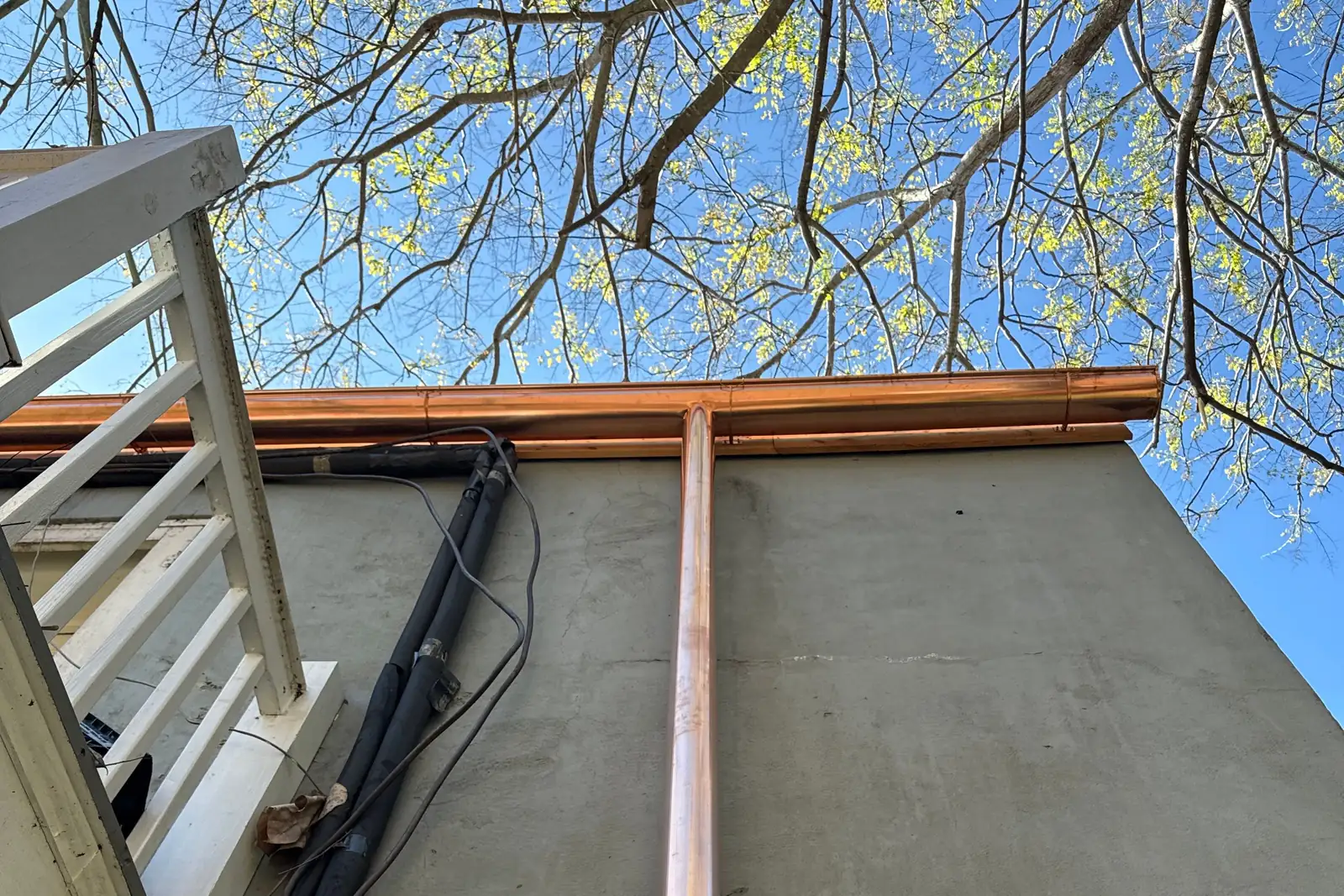 Slate roof edge with copper flashing and gutter detail on a historic home