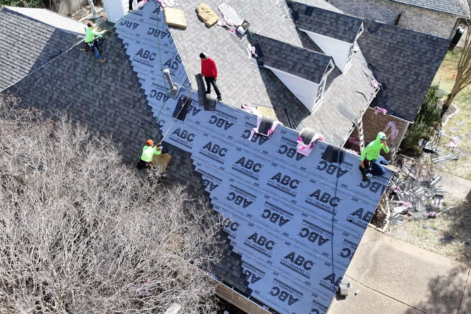 Crew installing architectural shingles over synthetic underlayment on an Austin home