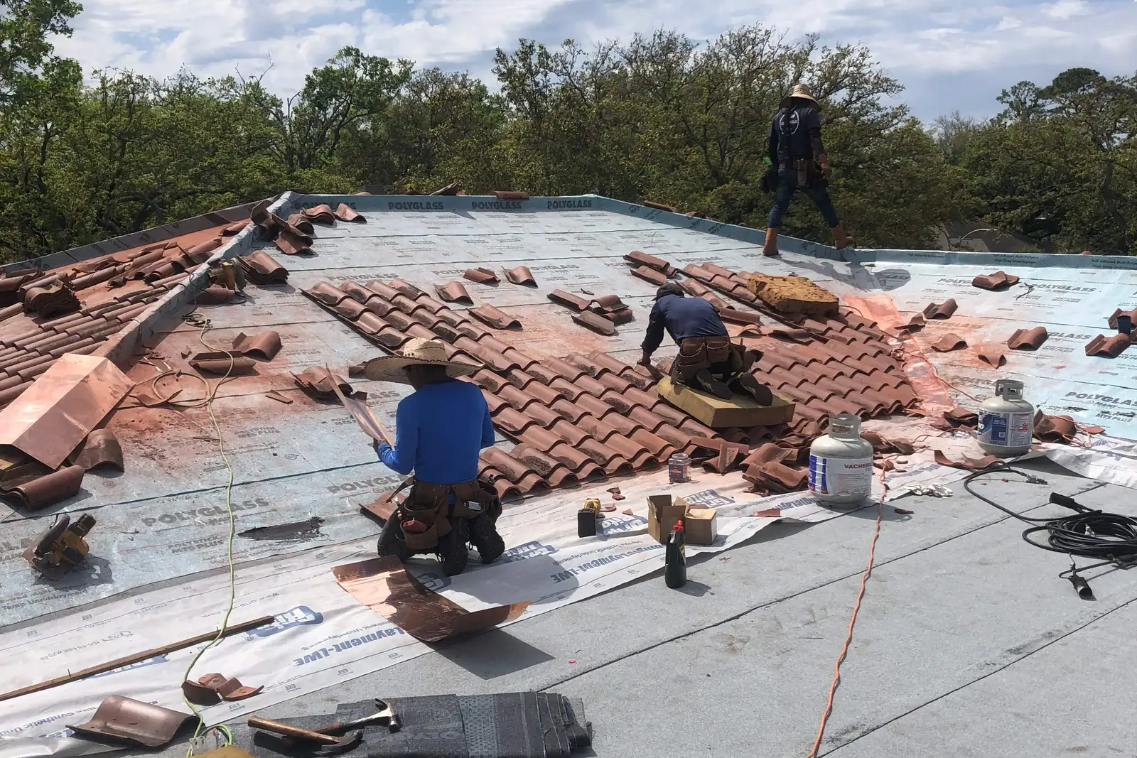 Crew replacing clay tiles over new underlayment in River Ridge