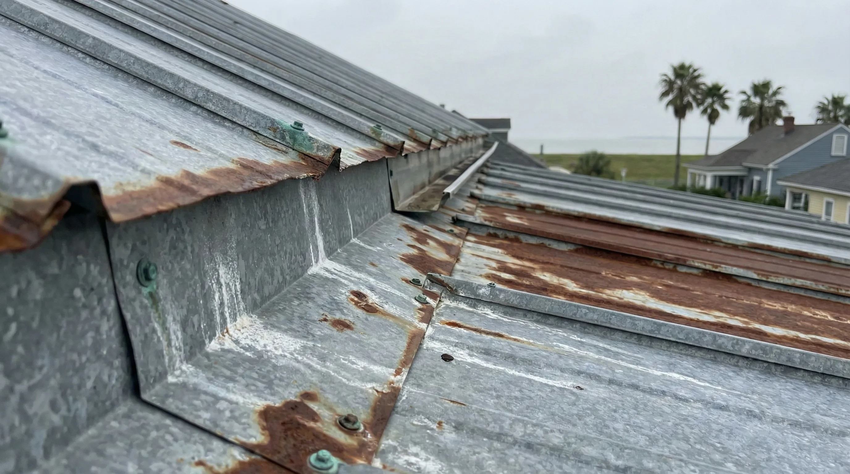 Corroded roof flashing on New Orleans home near Lake Pontchartrain showing salt air damage