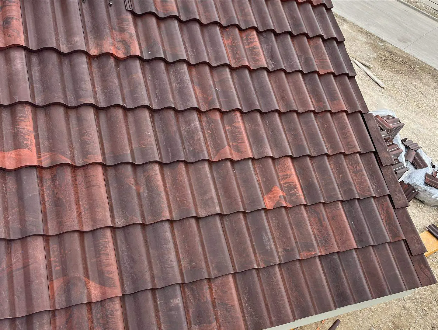 Clay barrel tiles staged in stacks during a tile roof installation