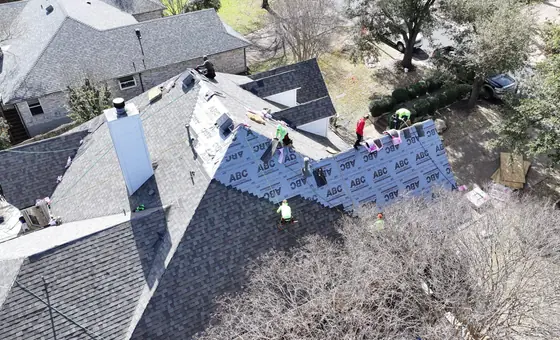Roofing crew installing asphalt shingles on a residence